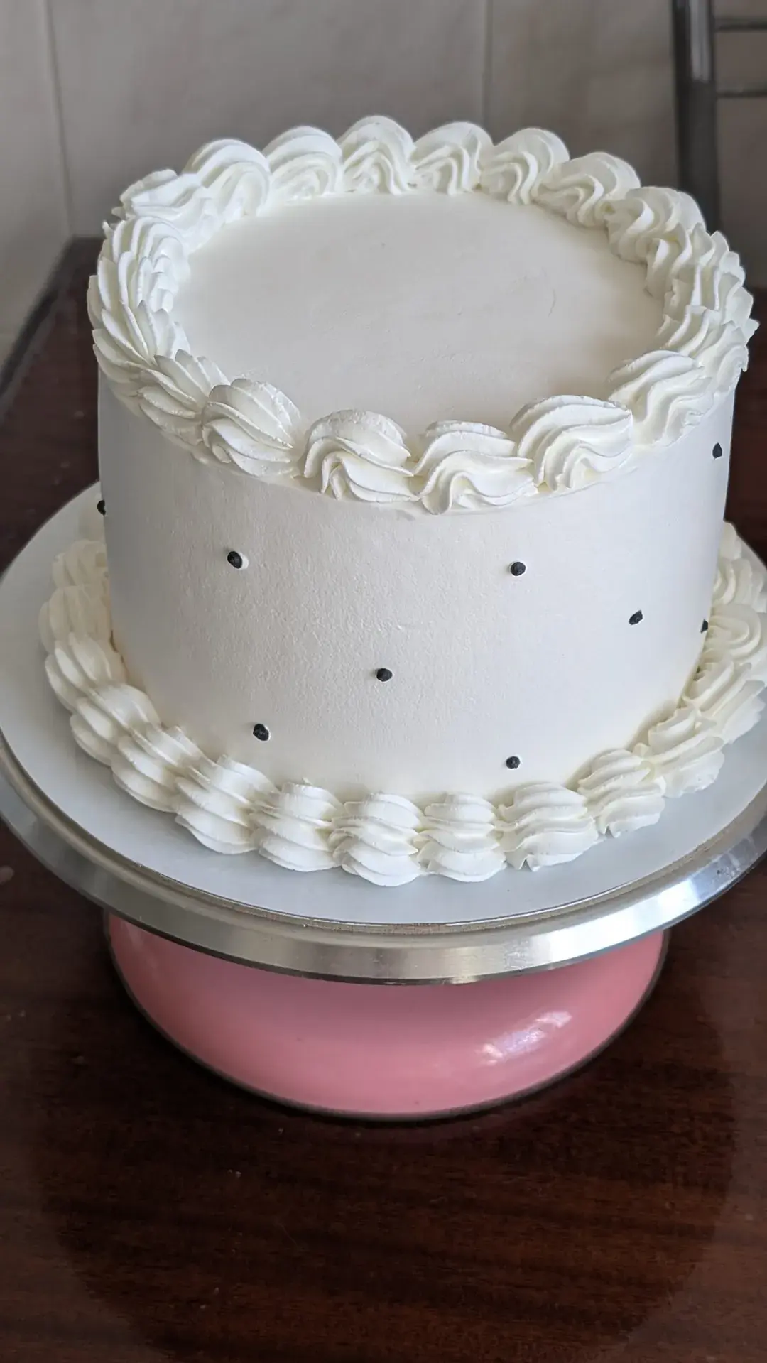 Bolo branco clássico com bordaduras de creme e pontos pretos